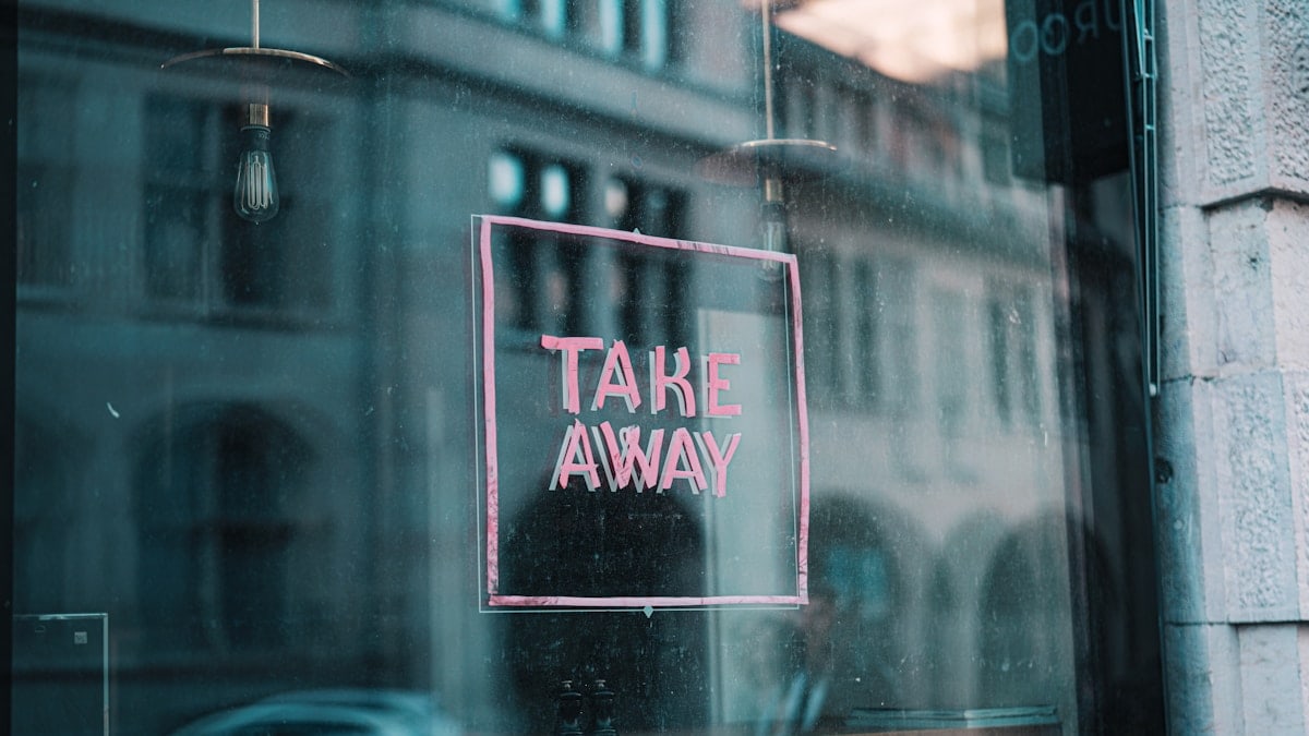 a window with a sign that says take away